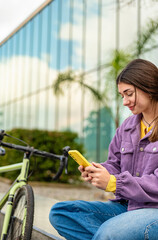 Young woman texting on her phone while relaxing outdoors