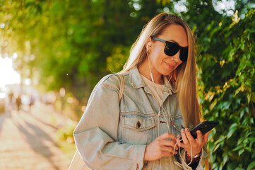 Artist in denim jacket sketches digital art on smartphone under willow tree, merging traditional...