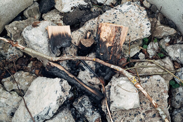 Fototapeta premium A pile of rocks and wood with a burnt log in the middle