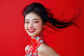 Studio portrait of beautiful smiling CHINESE woman in RED dress on RED solid background