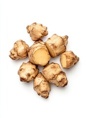 Close up view of several pale beige Jerusalem artichokes, some cut open to reveal a pale yellow interior, arranged on a white background.