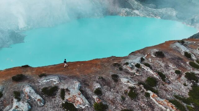 Man enyoing Misty Volcano of Kawah Ijen crater in East Java