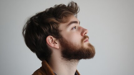 Fototapeta premium Side view of young bearded man isolated on white background