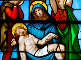 Stained glass (19th century) of the Piet&agrave;. Blessed Virgin Mary holding Jesus Christ body after his Deposition from the Cross.