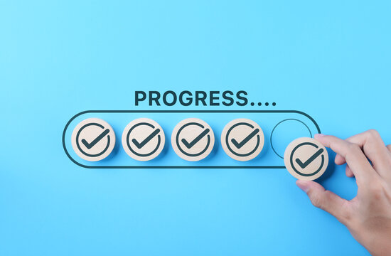 Checklist and task progress tracking concept. A hand placed the final checkmark on round wooden in progress bar, task completion, productivity, goal setting, efficient project management, loading bar,