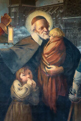 Painting of St. Vincent de Paul carrying a child in his arms.