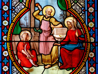 Fototapeta premium Stained glass (19th century) of Holy family: Jesus infant, Virgin Mary and St Joseph in the workshop of Joseph the carpenter.