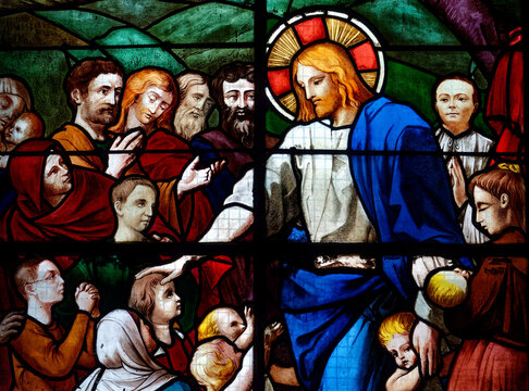 Stained glass (1926) of Let the children come to me! Children want to approach Jesus, who welcomes and blesses them.