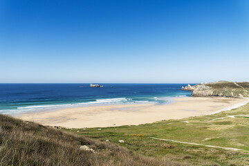 Depuis les hauteurs, la plage de Pen Hat s’étale en courbes harmonieuses. L’océan aux reflets bleus et verts se brise doucement sur le sable doré de la presqu'île de Crozon.