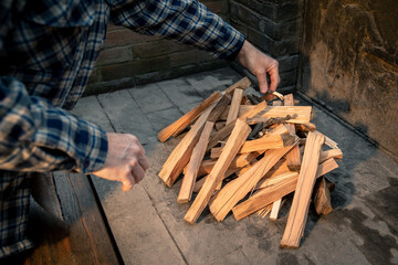 Man preparing a barbeque grill with a burning wood pyre. Male cooking meat and vegetables on fire...