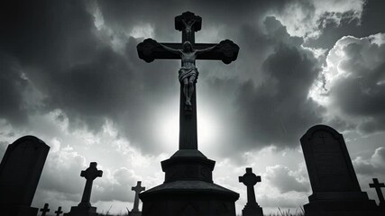 Dramatic backlit cross in a cemetery set against a cloudy sky.