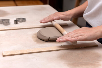 The process of kneading and manufacturing artisanal ceramics and clay by hand and with a wheel, showing the step-by-step process by the hands of a ceramics professional.
