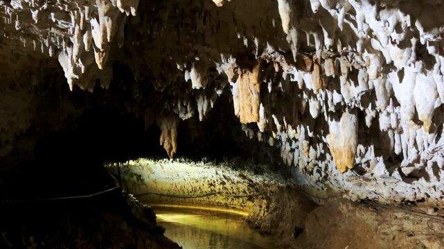 The bright and colorful Abrskil cave. A gallery-type cave in the mountains of Abkhazia with many stalactites and stalagmites, colorful lighting. Otapskaya (Otap cave). 4K	