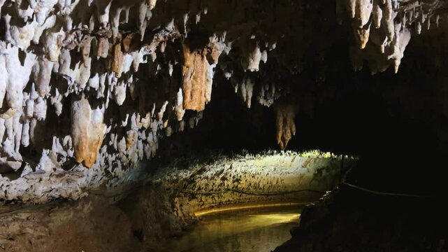 The bright and colorful Abrskil cave. A gallery-type cave in the mountains of Abkhazia with many stalactites and stalagmites, colorful lighting. Otapskaya (Otap cave). 4K