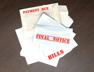 Large pile of envelopes with unpaid bills with warnings in red letters