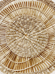 Fototapeta premium Close-up of a handwoven rattan or wicker texture. Natural material with warm, earthy tones, perfect for interior design, eco-lifestyle, or boho-inspired concepts.