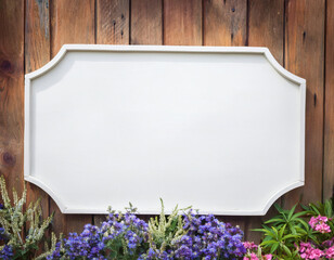 Blank white rustic wooden rectangle garden sign with floral and wood background. Empty rustic wood board on wooden fence with flowers. Mockup for home, garden, and business display.