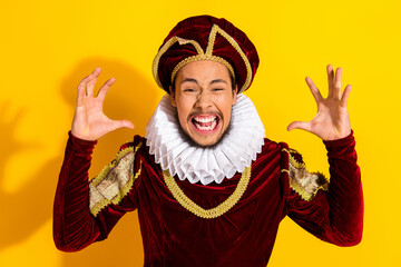 Young man in a royal costume expressing excitement against a vibrant yellow background