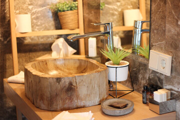 close-up of stylish bathroom with wooden sink and a plant and tissues in the interior