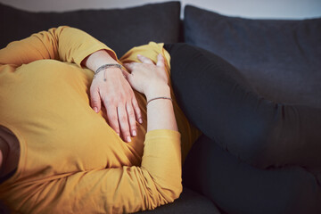 Woman with strong stomach ache, menstrual and digestive issues at home.