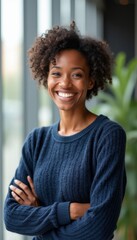 Fototapeta premium A radiant young woman with beautiful curly hair stands confidently with her arms crossed, exuding warmth and positivity. Her bright smile and engaging demeanor create an inviting atmosphere, perfect