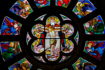 Stained glass (19th century) representing God in heaven supporting Jesus on the cross surrounded by angels.