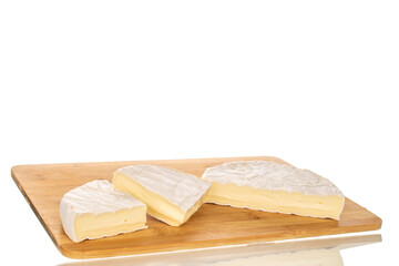 Pieces of fragrant brie cheese on a bamboo cutting board isolated on a white background, close-up.