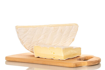 Pieces of fragrant brie cheese on a bamboo cutting board isolated on a white background, close-up.