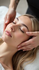 Fototapeta premium A serene young woman enjoys a soothing facial massage, her eyes closed in blissful relaxation. The gentle touch of skilled hands enhances her natural beauty, creating an atmosphere of tranquility and