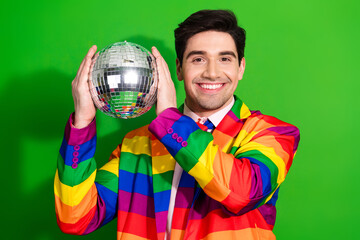 Young Handsome Male Wearing Rainbow Striped Suit Holding Disco Ball with Green Background