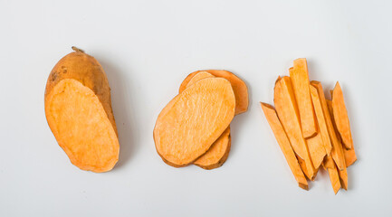 Several pieces of sweet potato, sliced ​​and cut into strips on a white background. Horizontal,...
