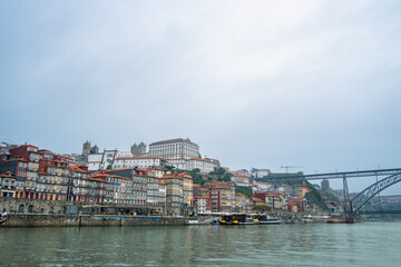 Naklejka premium Scenic view of Dom Luis I Bridge from a Douro River cruise. See Porto and Vila Nova de Gaia's colorful riverside architecture.