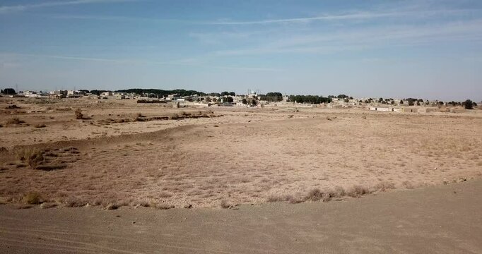 Drone aerial view of Iran desert village, rural landscape, clay houses, traditional architecture, remote settlement, dry terrain, Middle East scenery, mudbrick structures, adobe rooftops, historic