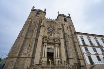Majestic Porto Cathedral, Portugal, captured from a low angle. Its grand stone facade and twin towers stand prominently against the sky.