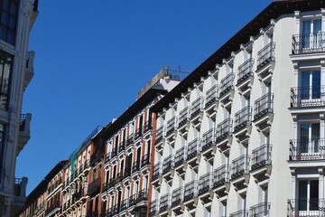 Brightly painted buildings line a lively street in Madrid during a sunny day