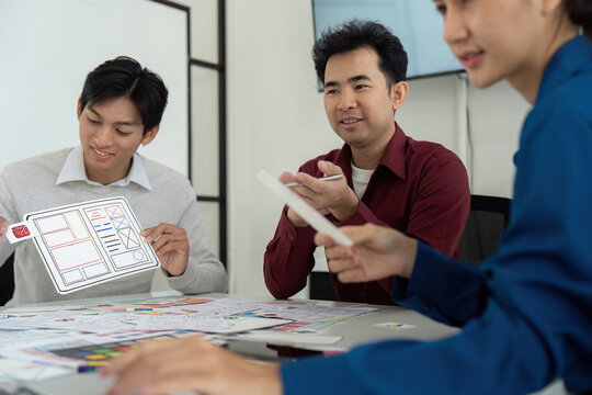 Collaboration and UX UI Design. A diverse group of professionals brainstorms UX UI concepts in a creative meeting setting.