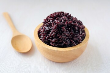 Steamed black sticky rice in wooden bowlon white background
