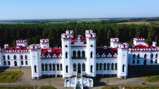 The Puslovsky Palace in Belarus. The Kossovsky Autumn Castle. An old historical castle in the style of English Gothic Revival in Kosovki in sunny autumn weather.Top view.Drone.4K