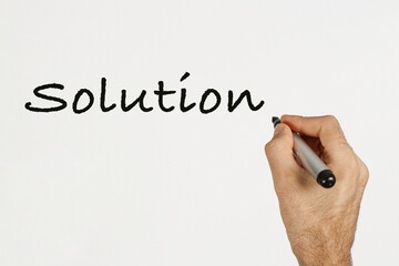 A man write 'Solution' on white board with black marker. Space for text. 