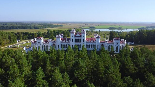 The Puslovsky Palace in Belarus. The Kossovsky Autumn Castle. An old historical castle in the style of English Gothic Revival in Kosovki in sunny autumn weather.Top view.Drone.4K