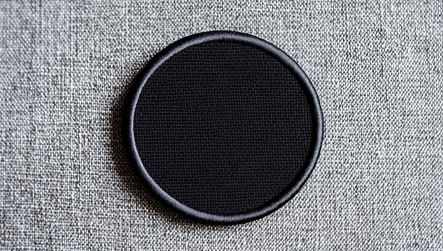 Blank black circle iron-on patch on gray fabric