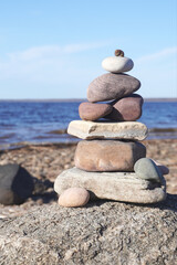 Balancing rocks forming a cairn on a beach with a snail on top