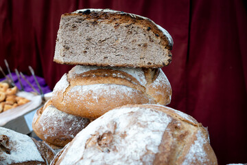 A loaf of bread is cut in half and placed on top of another loaf of bread. The bread is white and...