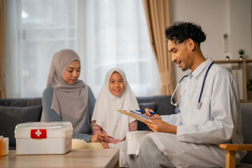 Obraz premium Isalamic Prediatician doctor give medical advise to Muslim mother and liitle kid at home, Delivery health for kid at home concept.