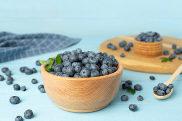 Bowl with fresh bright blueberries on wooden table