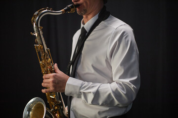 Cropped shot of male musician dressed in formal white shirt paired with black tie professionally...