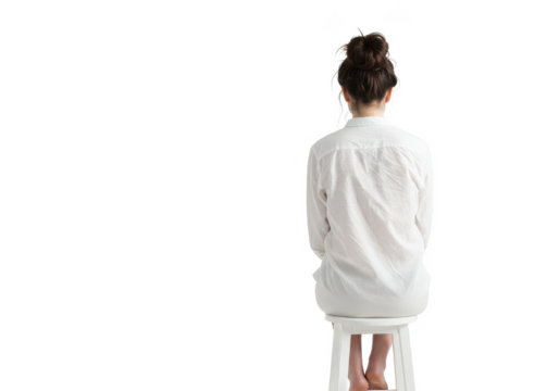 A woman sitting on a white stool with her back to the viewer wearing a white button down shirt on transparent background