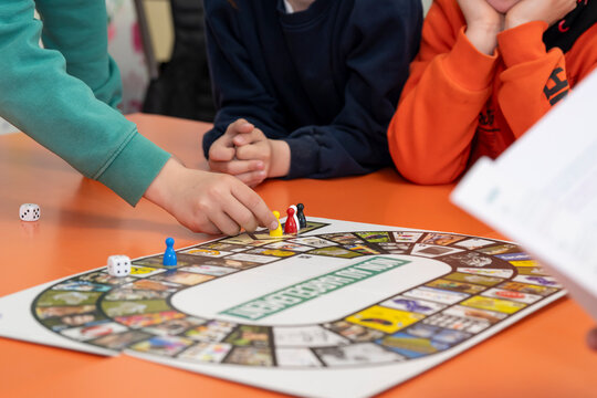 Mains d'enfant jouant avec des pions &agrave; un jeu de l'oie, jeu de soci&eacute;t&eacute; &agrave; plusieurs