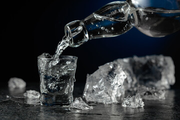 Crystal clear vodka or gin being poured into a glass.