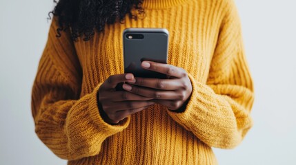 Woman with dark skin holding a phone with no visible face